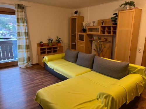 a living room with a yellow couch in a room at Hotel Kammerhof in Mariastein