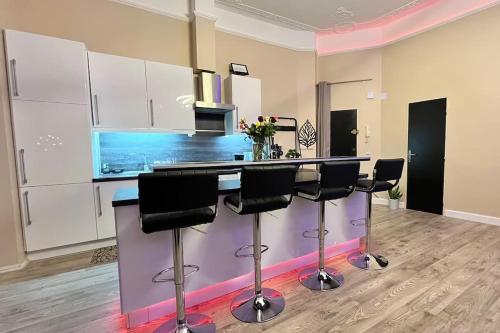 - une cuisine avec un comptoir et des tabourets dans une pièce dans l'établissement Appartement de luxe avec Jacuzzi au centre de Metz, à Metz