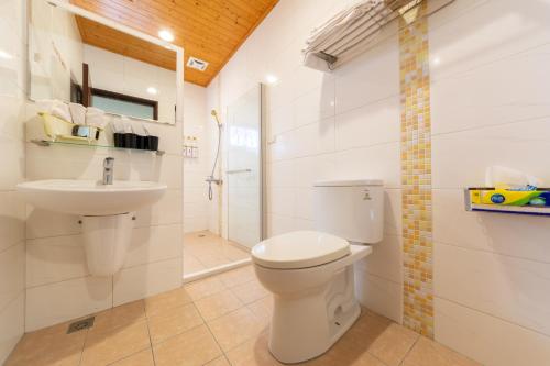 a white bathroom with a toilet and a sink at 時光輕旅 Time INN in Hengchun