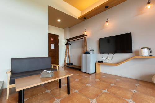a living room with a couch and a tv on the wall at 時光輕旅 Time INN in Hengchun