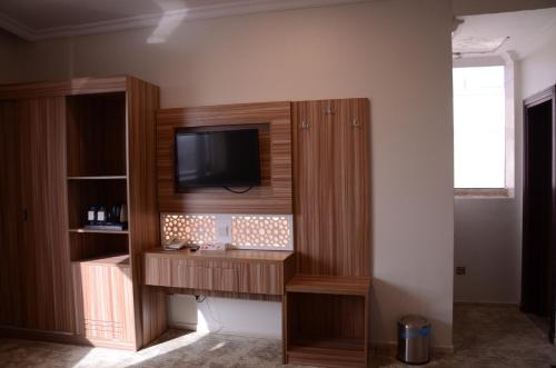 a entertainment center with a television on a wall at Artal Taiba Hotel in Al Madinah