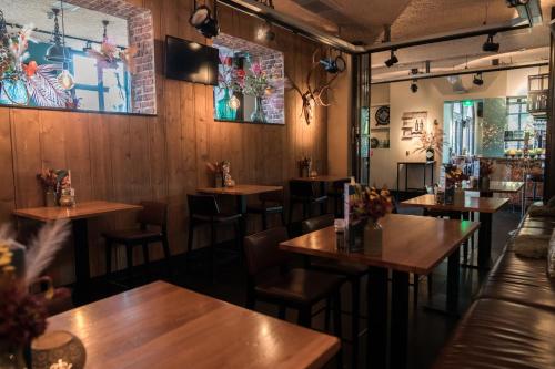 a restaurant with wooden tables and chairs at Boutique Hotel Brasa Beemster in Middenbeemster