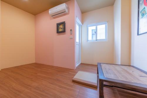 an empty room with a table and a window at 時光輕旅 Time INN in Hengchun
