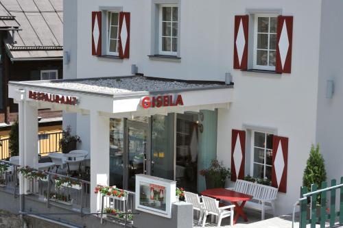 a restaurant with tables and chairs in front of a building at Hotel Gisela in Bad Gastein