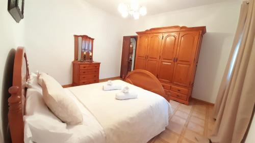 a bedroom with a bed and a wooden cabinet at Casa Rural Doña Catalina in Jimena de la Frontera