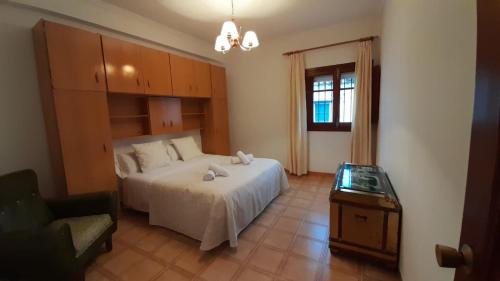 a bedroom with a bed and a chair and a table at Casa Rural Doña Catalina in Jimena de la Frontera