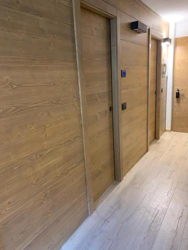 a room with two wooden garage doors and a wooden floor at Des Alpes C Flat 11 in Madonna di Campiglio