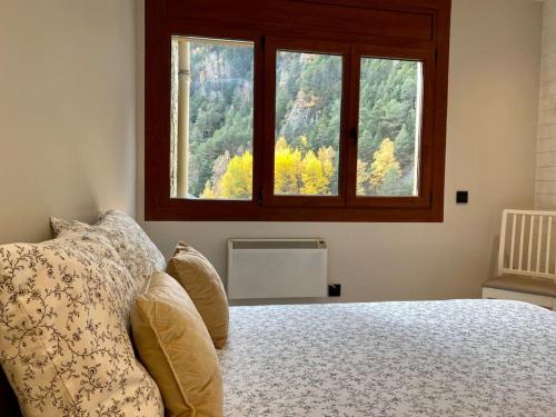 a bedroom with a large bed with a window at Prober Comapedrosa in Arinsal