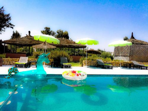 a swimming pool with a plastic giraffe in the water at Ferme Sacrée Nature in Ben Slimane