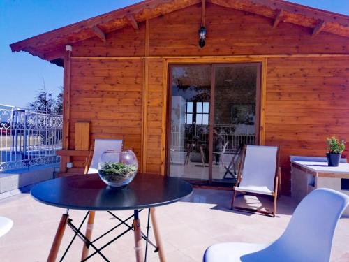 a wooden house with a table and chairs on a patio at Ferme Sacrée Nature in O Ben Slimane