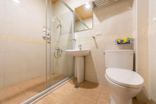 a bathroom with a toilet and a shower and a sink at 時光輕旅 Time INN in Hengchun