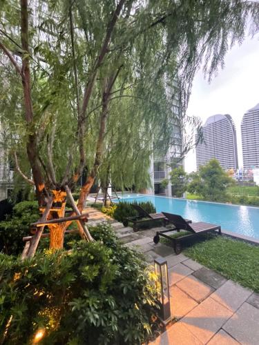 una piscina con albero e un tavolo da picnic accanto ad esso di Dolce Lasalle a Bangkok