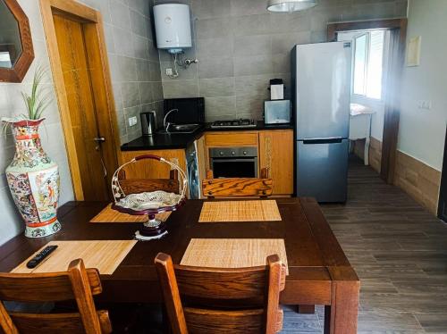 a kitchen with a wooden table and a refrigerator at Ferme Sacrée Nature in O Ben Slimane