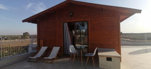a small building with chairs and a table on a balcony at Ferme Sacrée Nature in O Ben Slimane