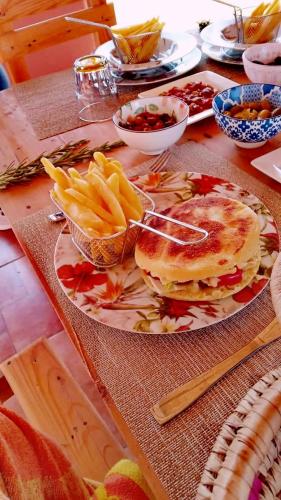 a table with a plate of food and french fries at Ferme Sacrée Nature in O Ben Slimane