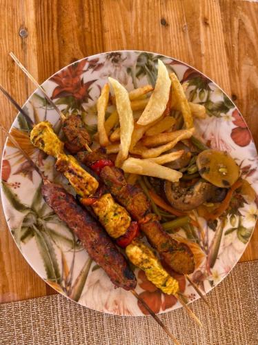 a plate of food with sausage and french fries at Ferme Sacrée Nature in O Ben Slimane