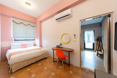a bedroom with a bed and a desk and a mirror at 時光輕旅 Time INN in Hengchun
