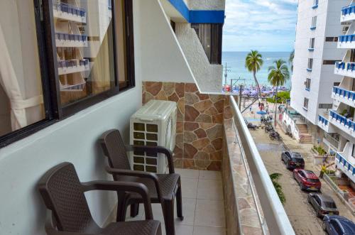 a balcony with chairs and a view of the beach at Apartamento con vista al mar en el Rodadero in Santa Marta