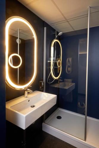 une salle de bain avec un lavabo blanc et un miroir dans l'établissement ibis Auxerre Centre, à Auxerre