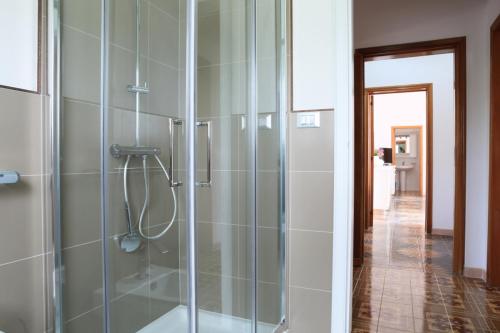 y baño con ducha y puerta de cristal. en Villa Oltremare, en Torre Suda
