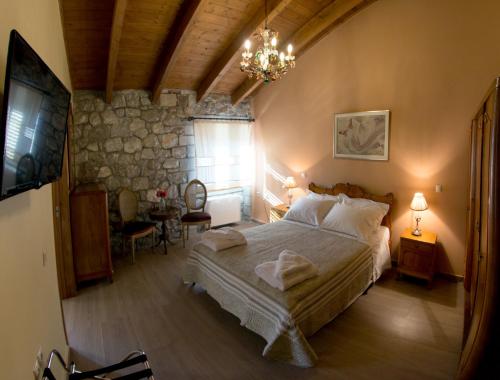 a bedroom with a large bed and a stone wall at Farma Sarli in Monódhrion
