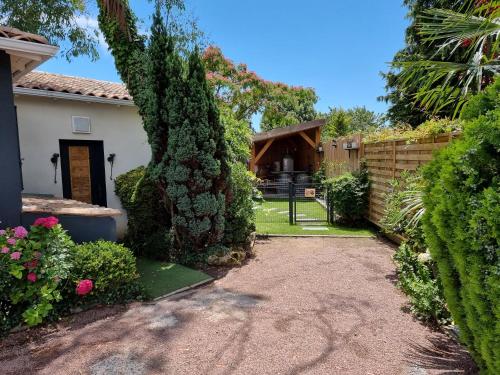 a yard with a house with a fence and bushes at Le Clos des Romarins in Saint-Palais-sur-Mer