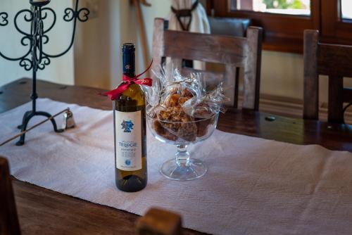 a bottle of wine and a bowl of food on a table at Livadi cozy villa in Arachova