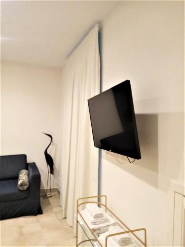 a living room with a tv on a wall at Divo Apartments - Spanish Steps in Rome