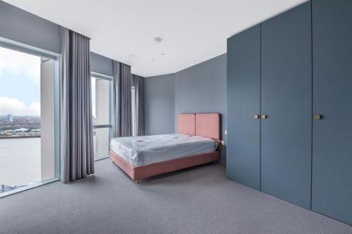 a bedroom with a bed and a large window at The Shypen - 2 bed in London