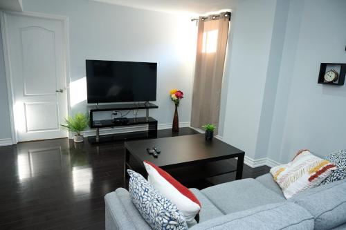 a living room with a couch and a tv at Peace Alcove in Milton