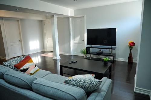 uma sala de estar com um sofá e uma televisão em Peace Alcove em Milton