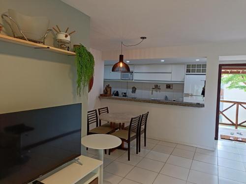 cocina y comedor con mesa y sillas en Apartamento Na Praia De Itacimirim, en Itacimirim
