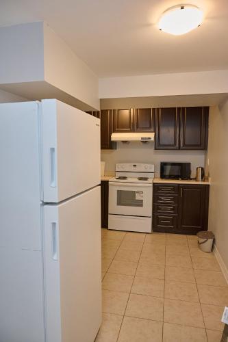 a kitchen with a white refrigerator and a stove at Peace Alcove in Milton