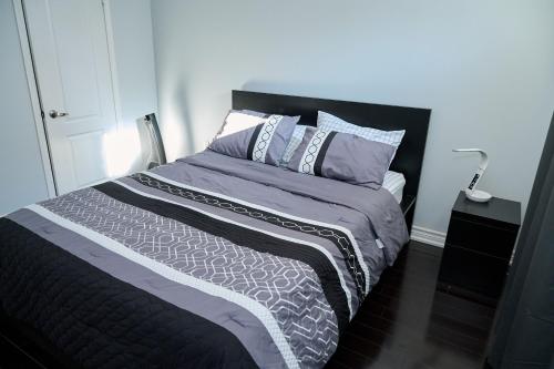 a bedroom with a bed with a black headboard and pillows at Peace Alcove in Milton
