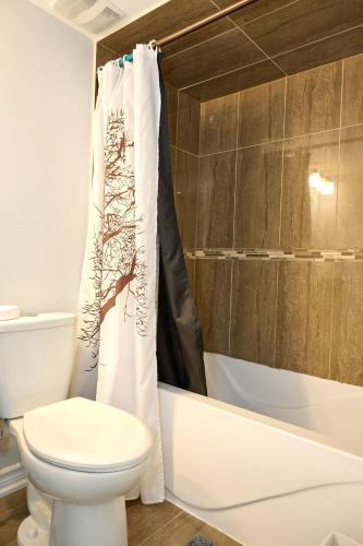 a bathroom with a toilet and a shower curtain at Peace Alcove in Milton