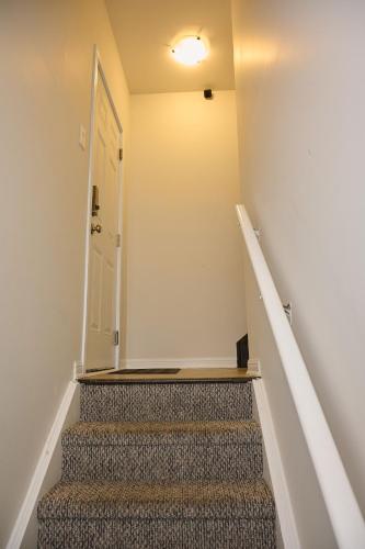 a hallway with stairs with a white door and a white door at Peace Alcove in Milton