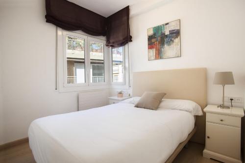 a bedroom with a white bed and two windows at 73cop1034 - Spacious apartment with terrace in Barcelona