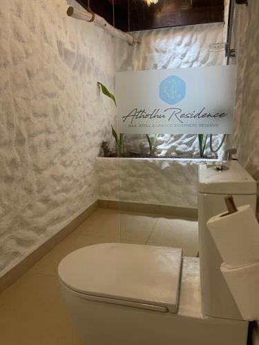 a bathroom with a white toilet and a sink at Atholhu Residence in Fehendhoo