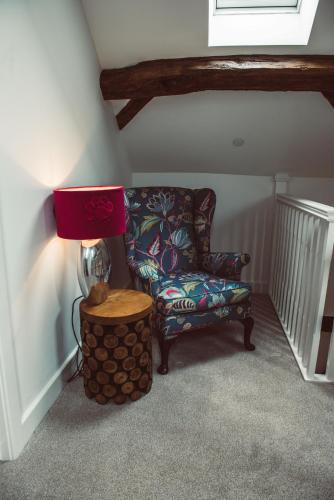 a room with a chair and a lamp and a table at Swallows Rest in Montgomery