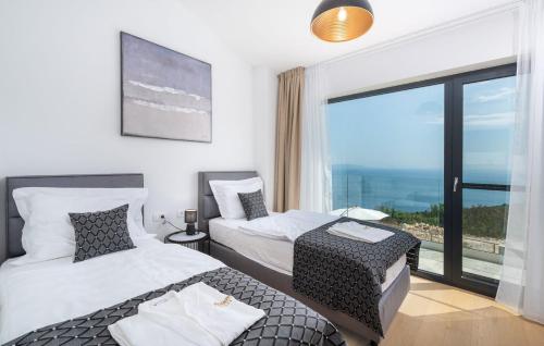 Una habitación de hotel con dos camas y una gran ventana. en Villa Atrium with heated pool, sea view, jacuzzi, gym and sauna, en Labin