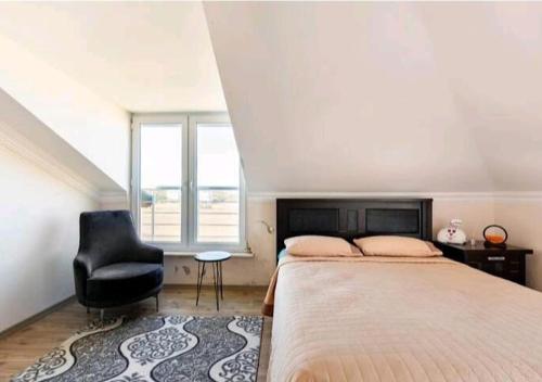 1 dormitorio con 1 cama grande y 1 silla negra en İstanbul havaalanı yanında deniz kıyısına sahip odalar en Arnavutköy