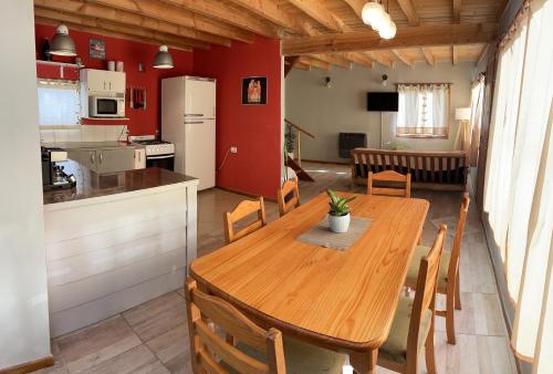 uma cozinha e sala de jantar com uma mesa de madeira e cadeiras em Hermosa y confortable casita en Bariloche em San Carlos de Bariloche