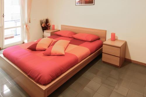 ローマにあるA Place Apartのベッドルーム1室(赤いシーツと赤い枕の大型ベッド1台付)