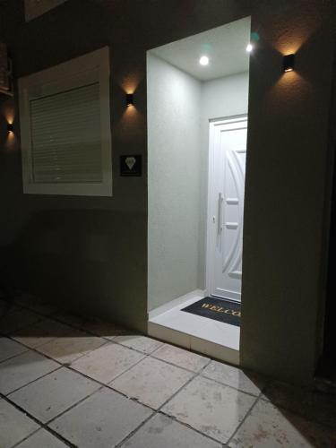 um corredor com uma porta branca e um espelho em K&K Luxury Loft Apartment em Serres
