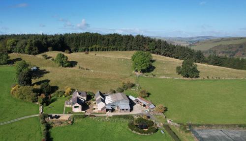 an aerial view of a large house in a field at The Stables at Pentregaer Ucha, tennis court & lake in Oswestry