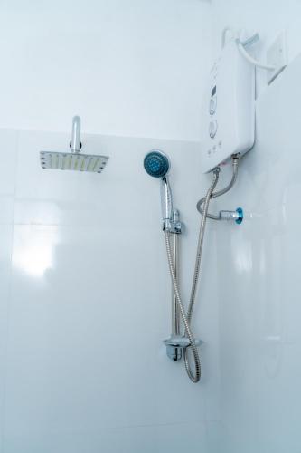 a shower in a white bathroom with a shower at Rainforest Holiday Inn in Deniyaya