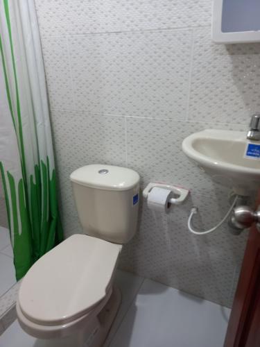 a bathroom with a toilet and a sink at Hotel CHAFO in Leticia