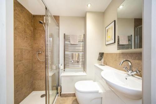 uma casa de banho com um WC, um lavatório e um chuveiro em Stylish two bed flat, city centre, free parking em Wells
