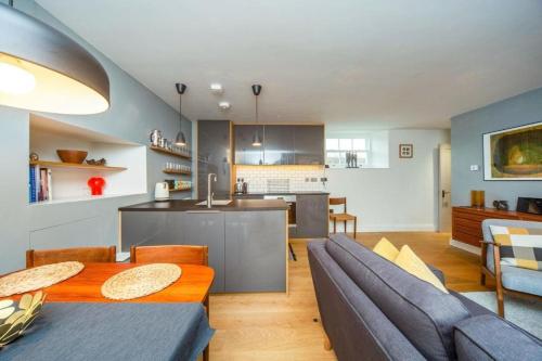 a living room and kitchen with a table and a couch at Stylish two bed flat, city centre, free parking in Wells