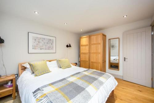 1 dormitorio con 1 cama grande y armario de madera en Stylish two bed flat, city centre, free parking en Wells